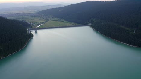 Vista-Aérea-De-La-Presa-Frumoasa-Con-Vistas-A-La-Montaña-Al-Amanecer-En-Rumania