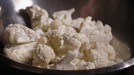 vista de primer plano de la coliflor sazonada con sal, especias y aceite - toma constante