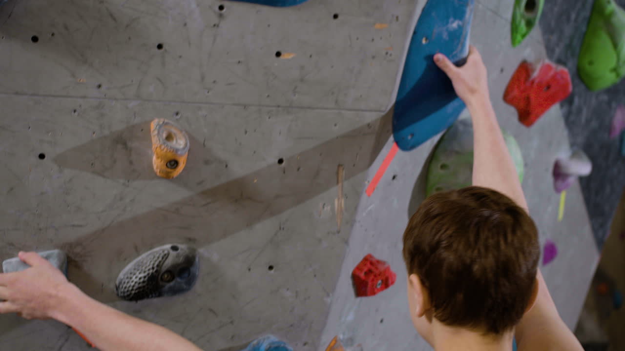 Menino praticando bouldering em um ginásio