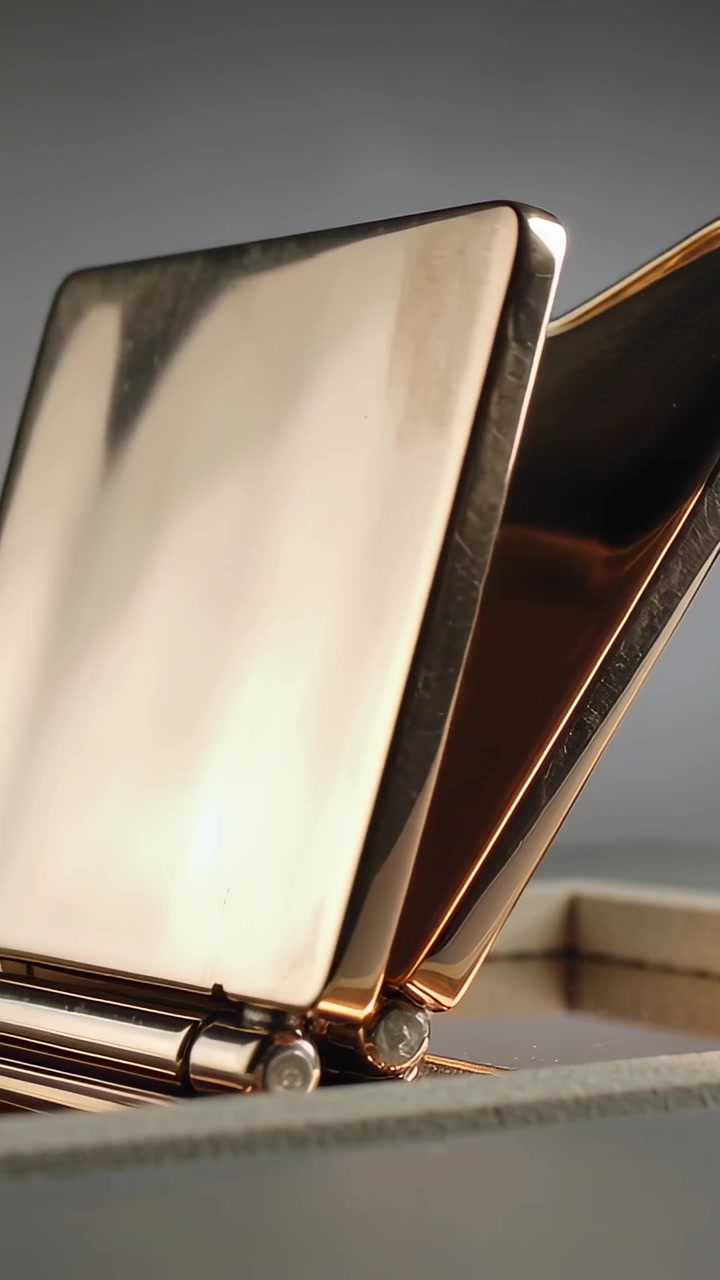 Vertical video: Turning hinge folding metal device pivoting at tabletop, revealing panels, pins
