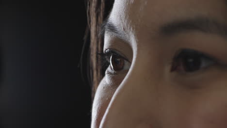 young-woman-eyes-looking-happy-cheerful-asian-woman-face-on-black-background-copy-space-close-up