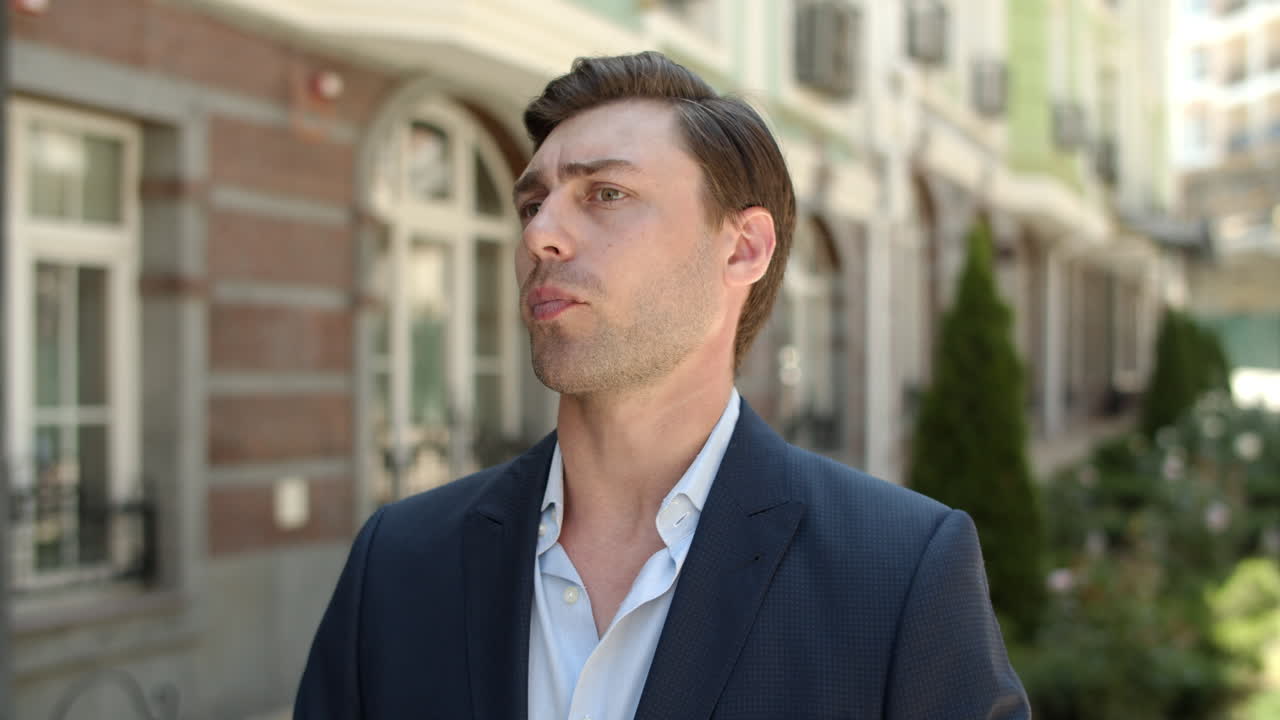 가까운 남자가 거리에서 파트너를 기다리고 있다. 남자가 스마트 워치에서 시간을 확인하고 있다.