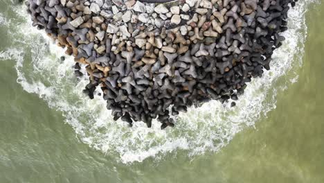 sea wave crashing tetra concrete block on wave breaker stone at molhe da barra de itajaí, santa catarina, brazil