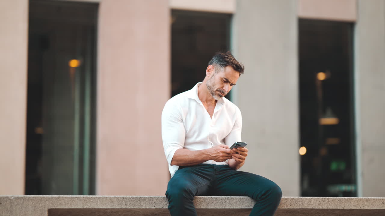 Man sitting outdoors using smartphone