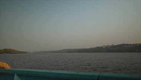 the scenic view from the side of a boat as it travels up the mondovi river on a beautiful sunny day, goa, india