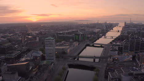 Vista-Aérea-De-La-Ciudad-De-Dublín-Al-Amanecer,-Hermoso-Movimiento-Sobre-El-Río-Liffey-En-El-Corazón-De-La-Capital-Irlandesa