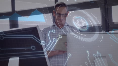 Using tablet, businessman analyzing data with digital interface overlay in office