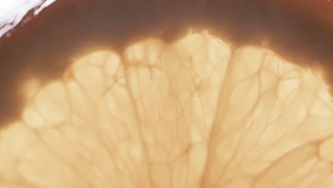 Micro-video-of-close-up-of-slice-of-orange-with-copy-space