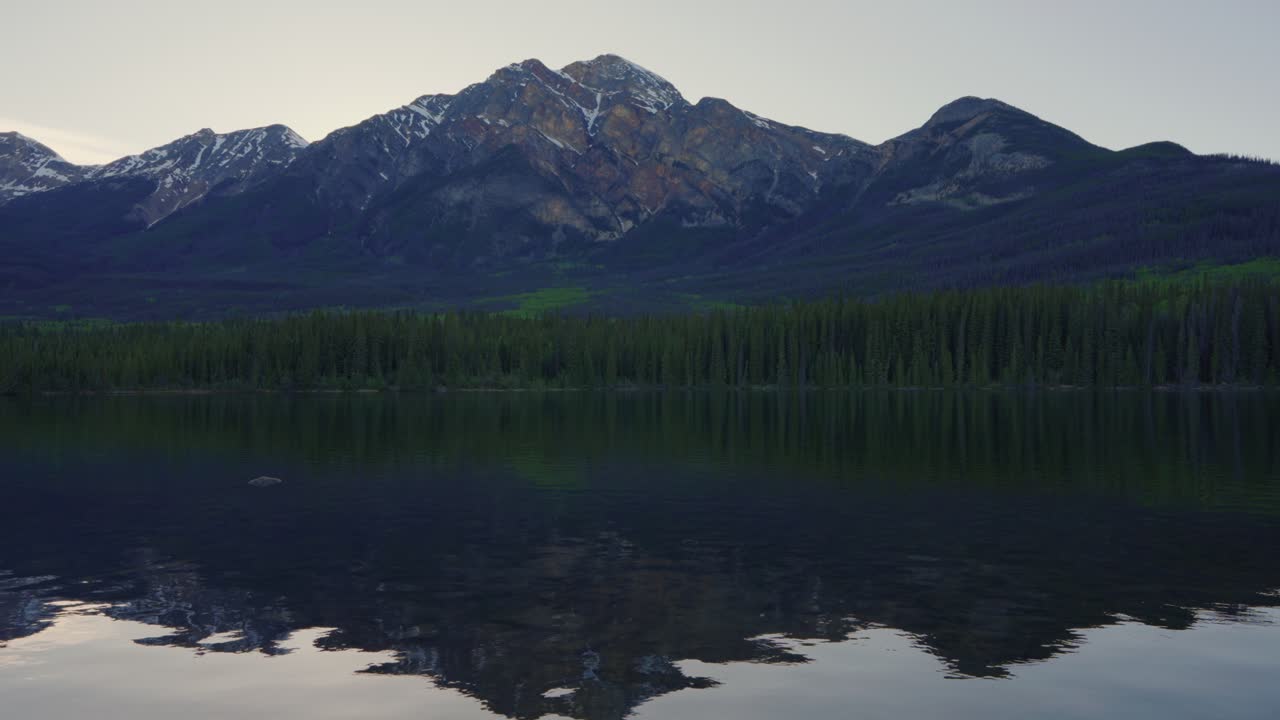 Lago Pyramid che riflette le Montagne Rocciose innevate nel Parco Nazionale Jasper al tramonto, Canada.