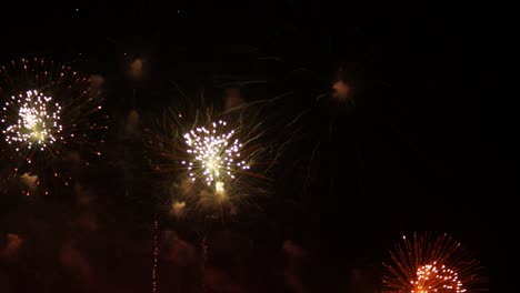 bursting colorful lights filling the night sky at a beachfront in a popular tourist destination in southeast asia during an international fireworks festival