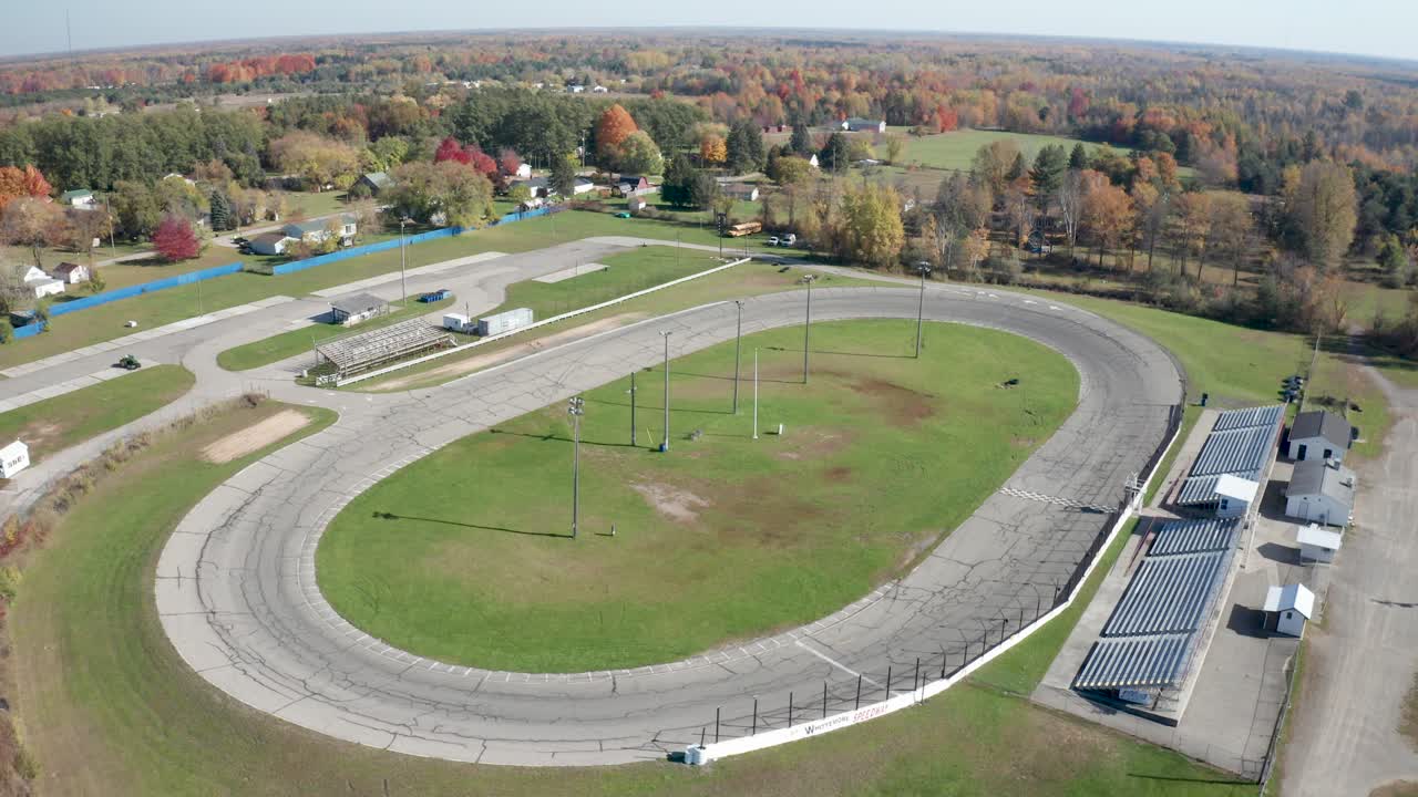 circuito de carreras de autos de pista pequeña de whittemore en whittmore, michigan con un video de un dron moviéndose hacia arriba en un ángulo