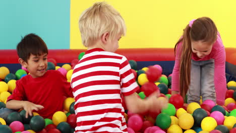 cute children playing and having fun in the ball pool