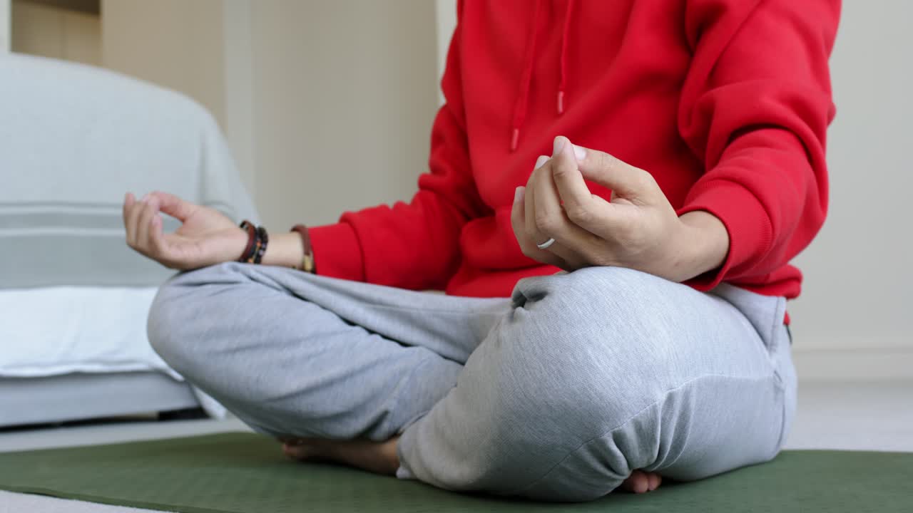Jednotlivec si pokládá ruce na kolena v mudře Džňána, aby zahájil meditaci, a klidně dýchá