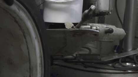 la vista estática de sacar un neumático viejo de la llanta en la máquina especial del taller