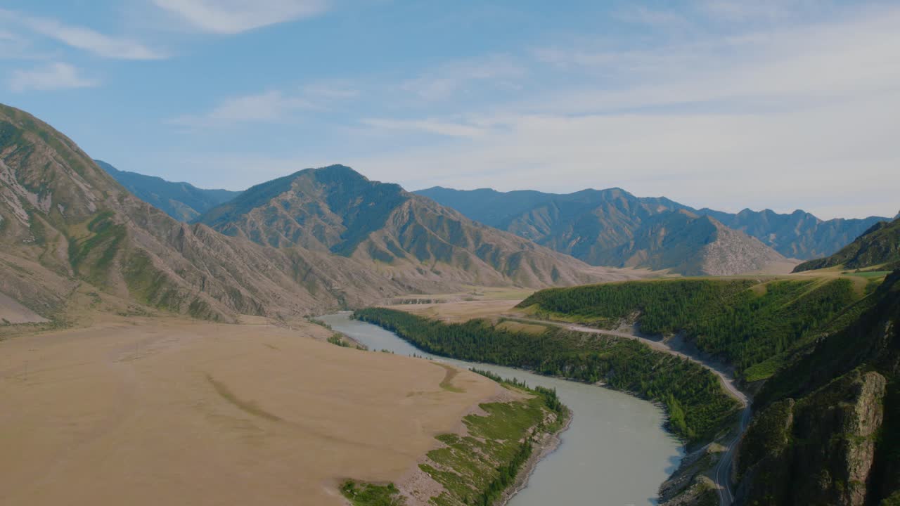Vidsträckt flygpanorama över floden Katun som slingrar sig genom en bred dal med klippiga berg och gröna kullar, Altai-republiken, Ryssland, en klar sommardag.