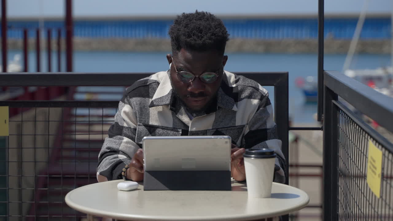 Man using tablet at an outdoor cafe
