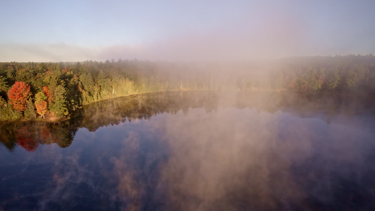 Cinematic drone pass capturing morning vapor rising from the water