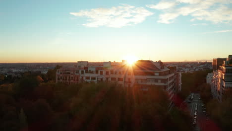 Vorwärts-Fliegen-über-Bäume-In-Parks-Und-Wohnhäusern.-Enthüllendes-Stadtbild-Und-Sonnenuntergang-Am-Horizont.