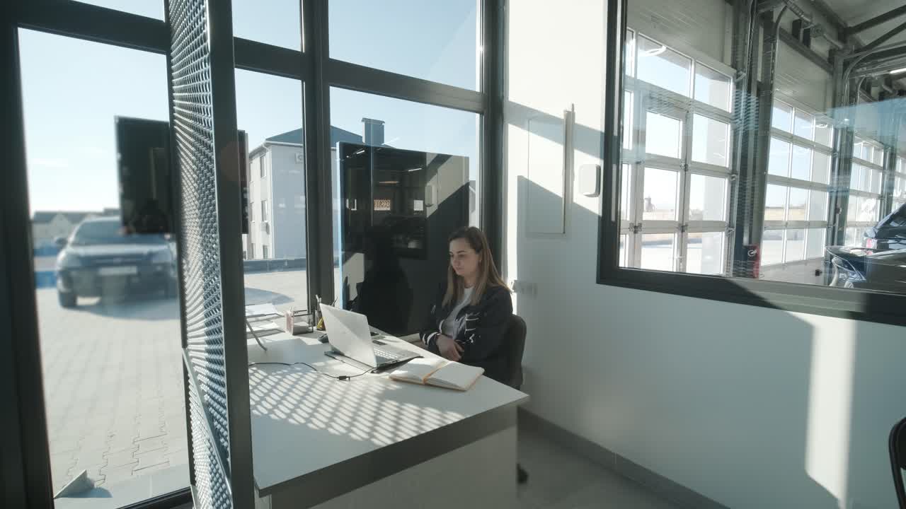 менеджер по обслуживанию автомобилей, работающий за столом в офисе