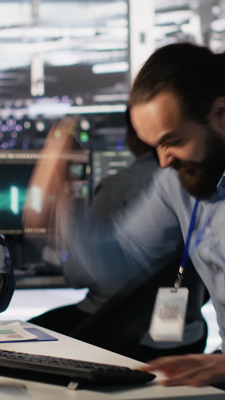Vertical video Angry data center engineer banging fist on desk after seeing system failure