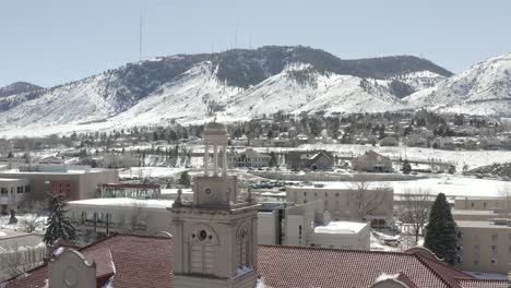 An-aerial-shot-moving-backwards-from-a-small-tower-in-the-middle-of-a-town-during-winter