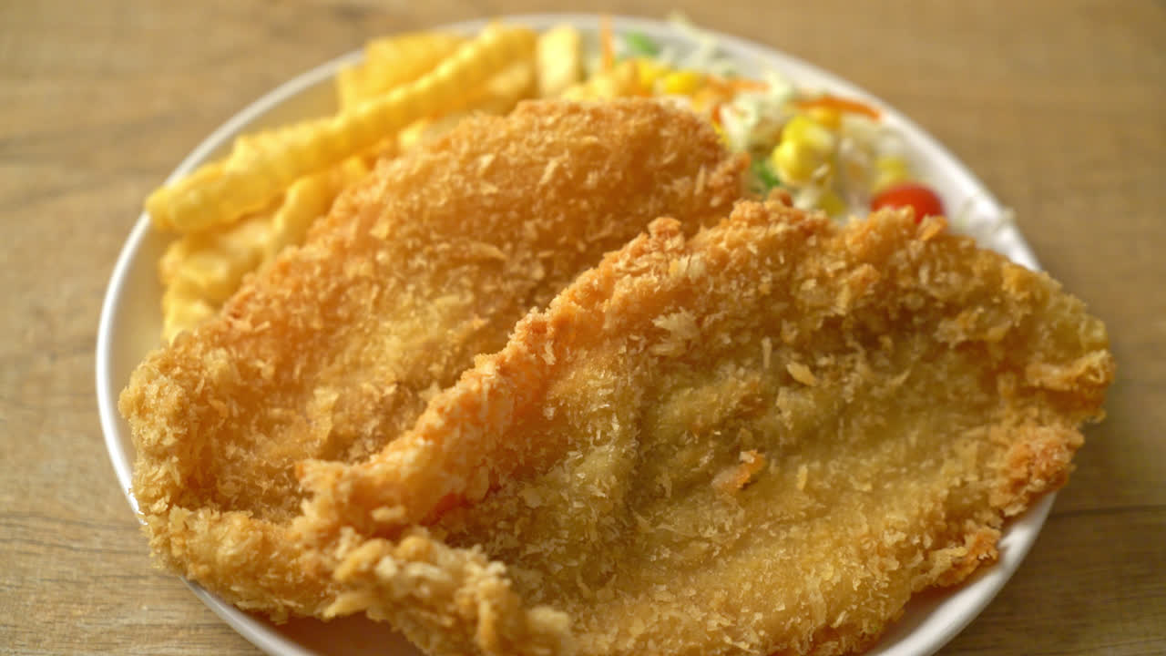 하얀 접시에 미니 샐러드를 곁들인 피쉬 앤 칩스