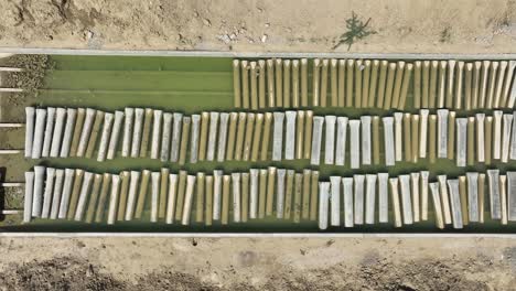 Aerial-Overhead-View-Of-Large-Floating-Steel-Pipes-In-Water-Tank-Outside-At-Pipe-Making-Factory-In-Pakistan