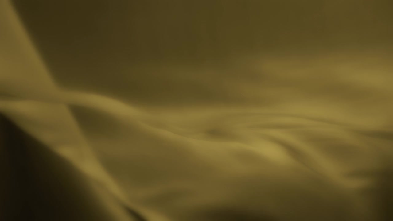 Yellow chiffon wavy fabric flowing in the wind. Slow motion