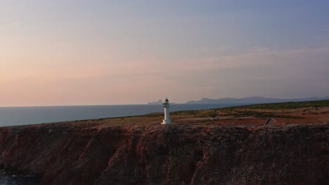 breathtaking circle shot of lighthouse on majestic rocky cliff, golden hour