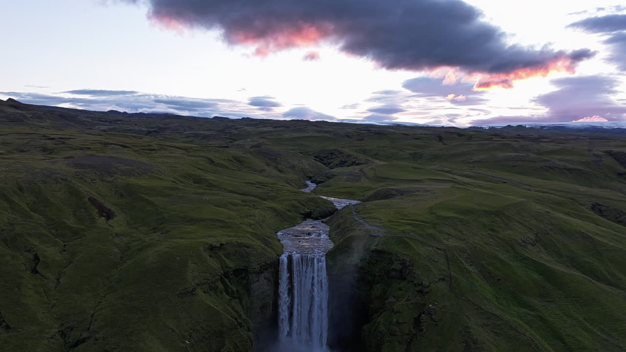 Hyperlapse drone shot of sunset clouds above the Skogafoss waterfall, in Iceland
