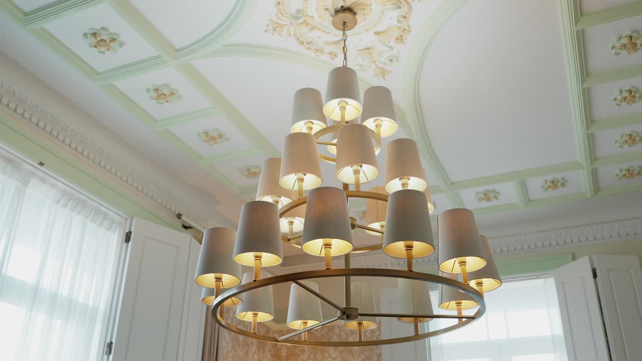 refined tiered chandelier hanging in classic room with soft decorative ceiling
