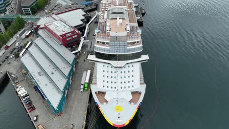 overhead aerial view of a large cruise ship docked in seattle while passengers prepare for departure