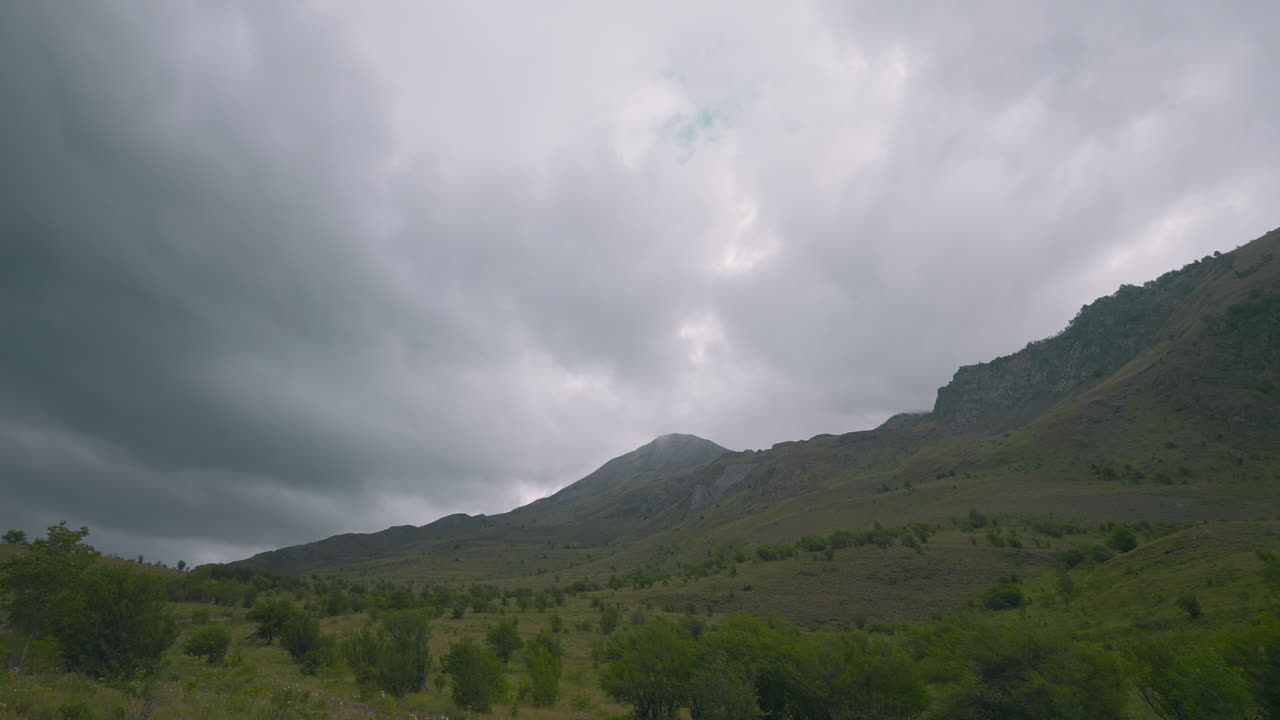 구름이 가득한 하늘 아래의 산악 풍경