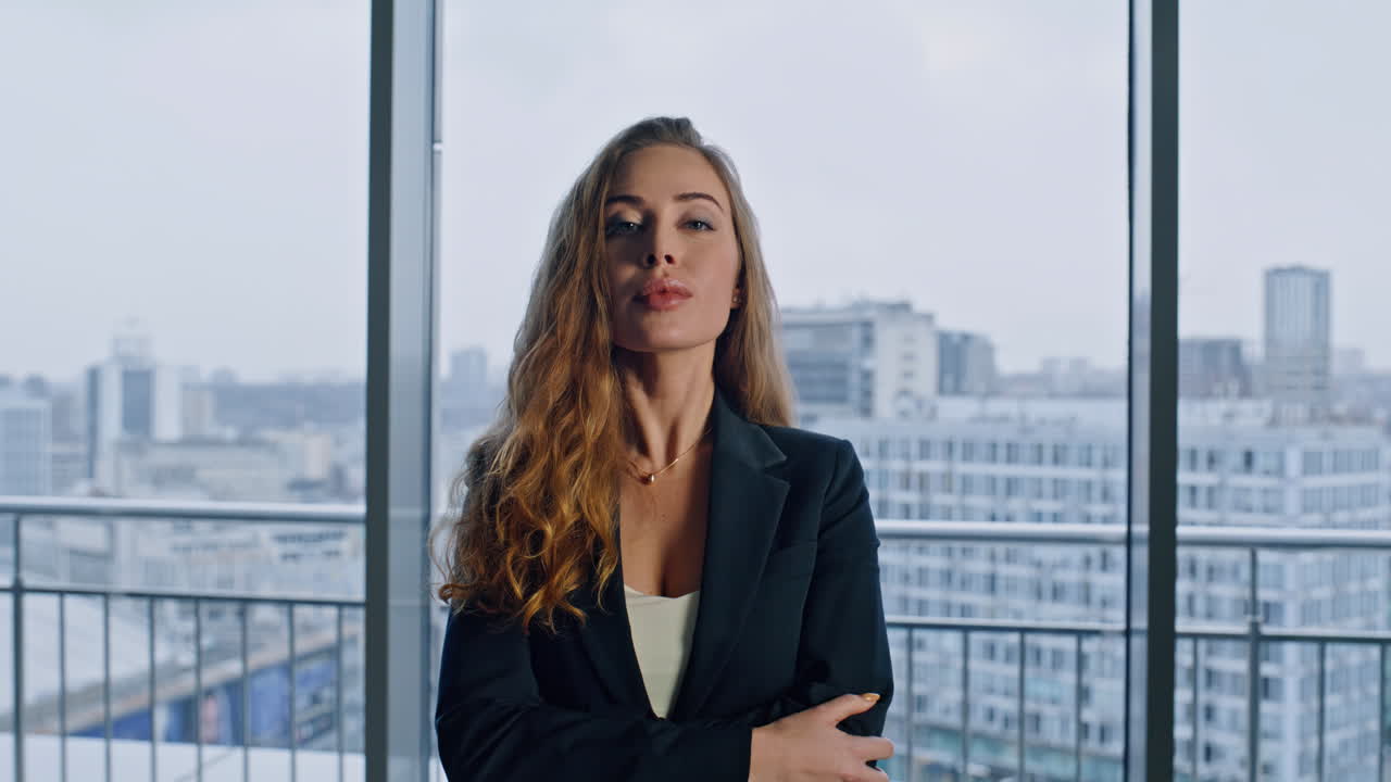 Retrato de una elegante empresaria mirando a la cámara en una oficina panorámica. La rica directora ejecutiva posa