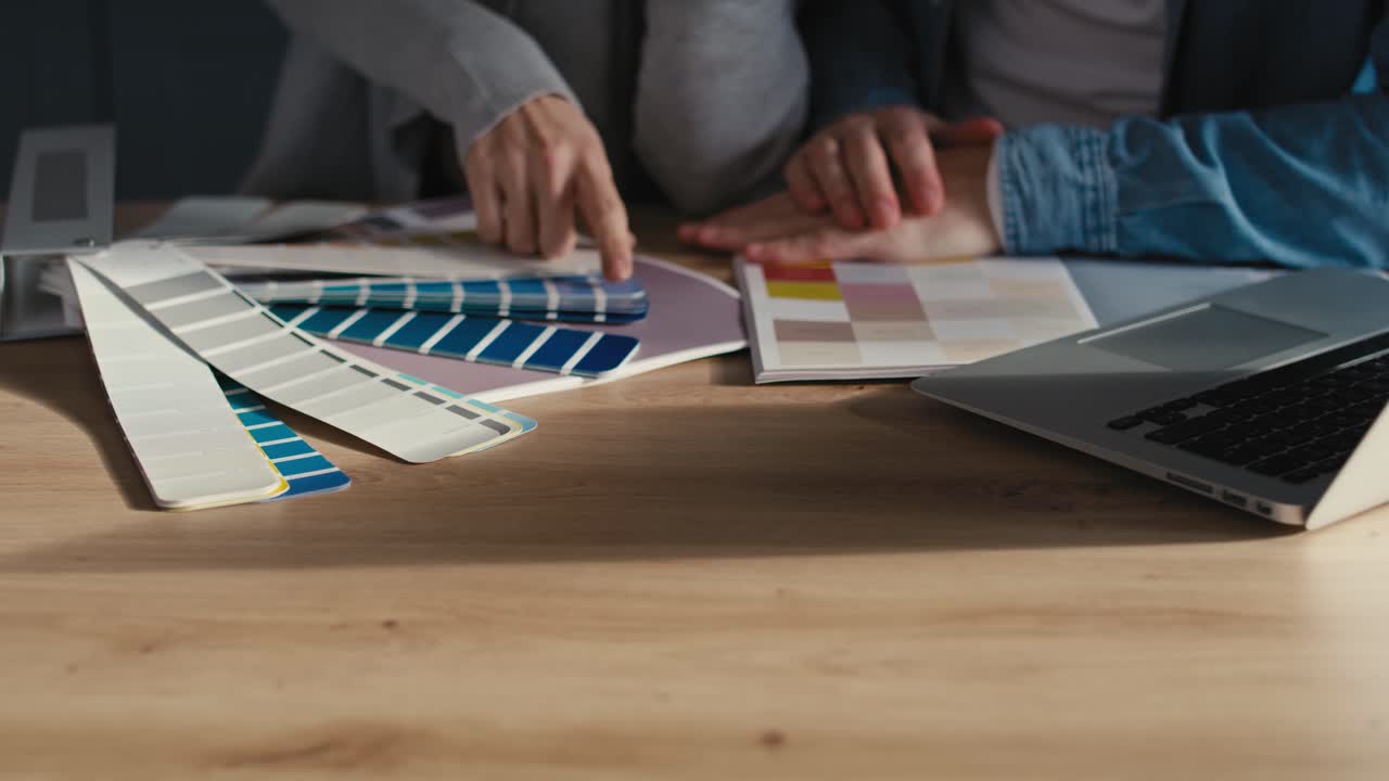 detalle de una pareja eligiendo colores para una casa nueva.