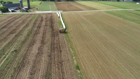 aerial view of amish farmer seeding his field with 6 horses