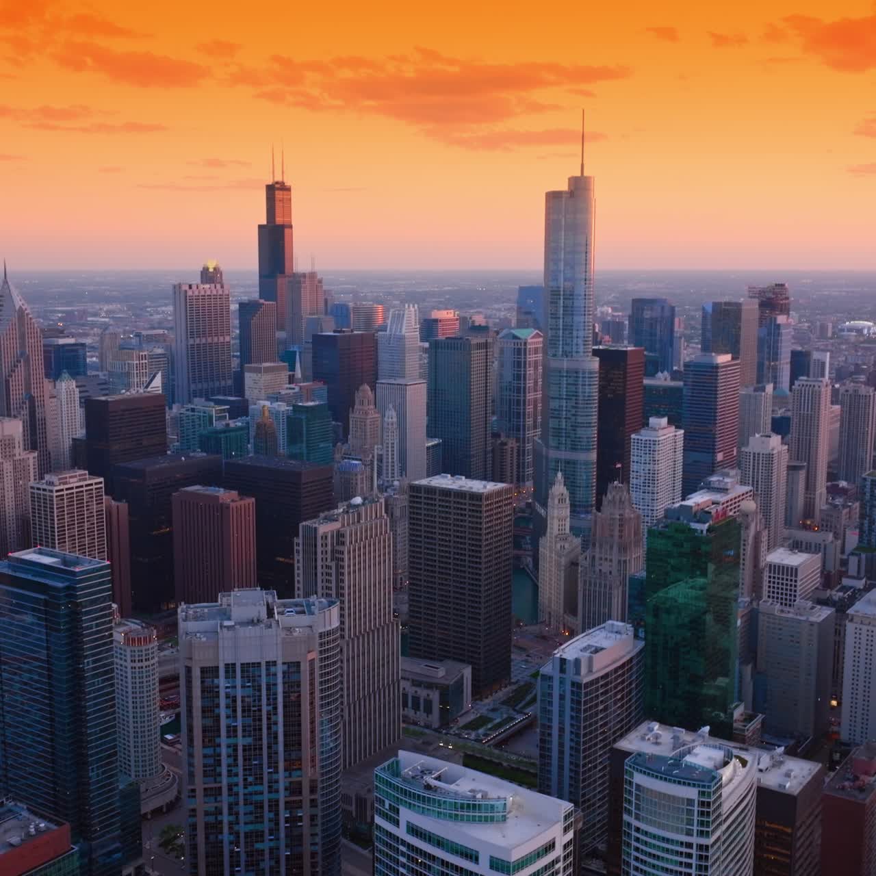 Futuristic Chicago downtown scenery at the backdrop of orange sky. Impressive skyscrapers at the background of plain cityscape