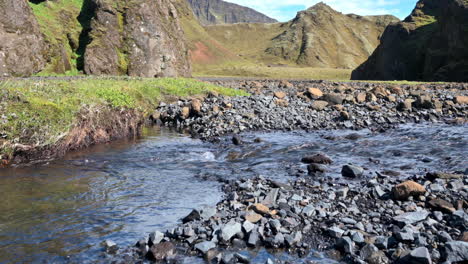 Gebirgsbach,-Der-Auf-Schwarzen-Kiessteinen-Im-Tal-In-Island-Fließt