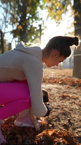una mujer con un pug en un parque.