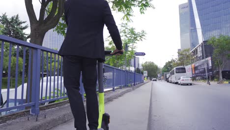 hombre en traje formal montando scooter eléctrico en la ciudad.