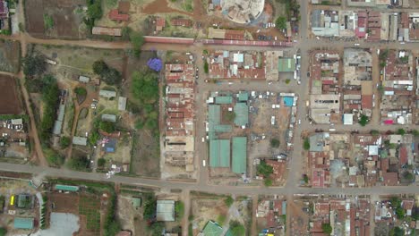 aerial view of a town and sunlit fields, golden hour in rural africa - tracking, drone shot