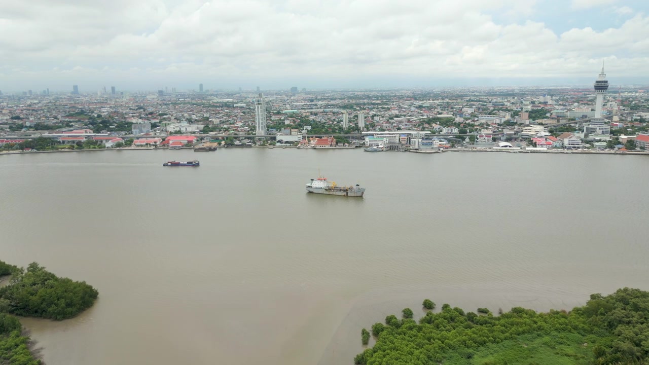 Navios transportam carga ao longo do Rio Chao Phraya, de cor marrom, em Bangkok, Tailândia. Drone avança. 4K 60FPS.