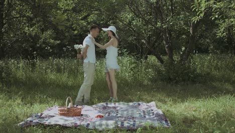 handsome man proposing to beautiful girl on picnic