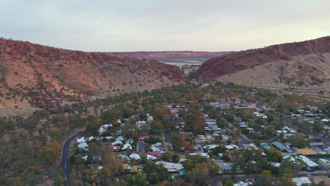 Aerial view moving towards Heavitree Gap at sunset, Alice Springs. Northern Territory, Australia. August 2022.