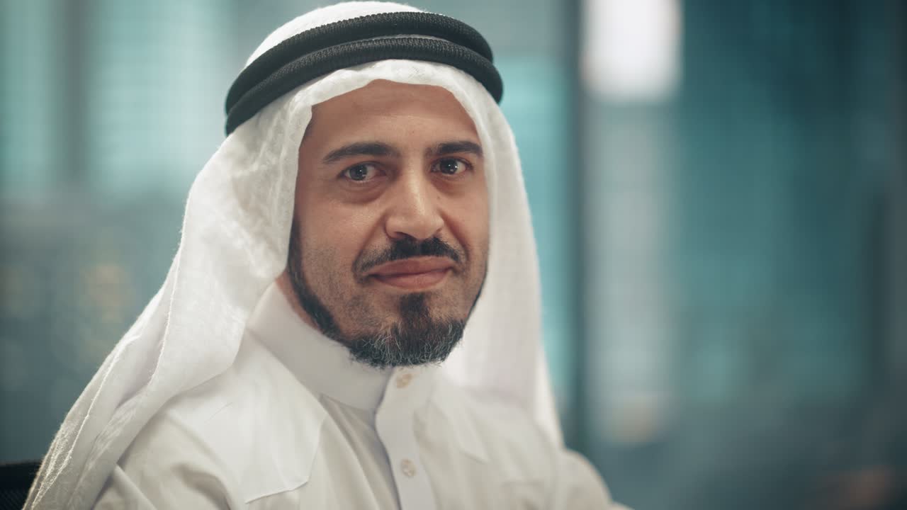 retrato de un exitoso empresario árabe en traje tradicional sonriendo suavemente, con kandura blanca y agal negro manteniendo un ghutra en su lugar. concepto de empresario árabe saudí, emiratí.