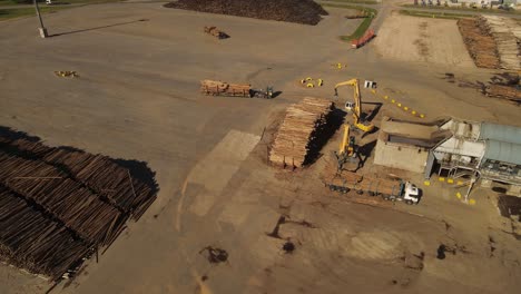 toma de drones de grúas industriales agarrando baúles de camiones cargados en fábrica de papel