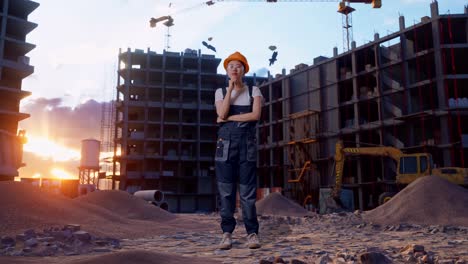 cuerpo lleno de trabajador mujer asiática con gafas de protección y casco de seguridad pensando en algo y mirando a su alrededor mientras está de pie en el sitio de construcción