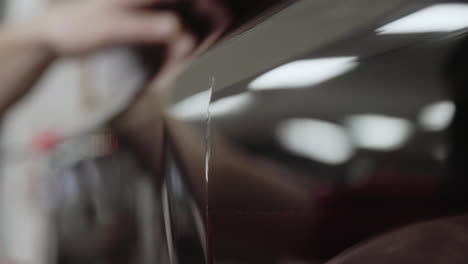 close-up of using an xacto blade to pre-cut protective paint film before applying it to a car