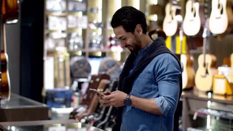 young handsome man using smartphone and payment by smartwatch contactless