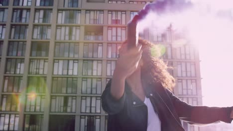 Fashionable-young-woman-on-urban-rooftop-using-a-smoke-grenade